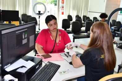 Marília fazendo a coleta biométrica.